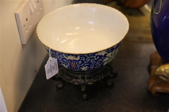 A Chinese blue ground porcelain bowl, Qianlong mark, late 19th / early 20th century, 21.5cm diam., wood stand